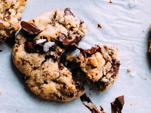Des cookies aux pépites de chocolat fondantes, parfaits pour apprendre comment faire des cookies maison. Le chocolat coule, invitant à la dégustation.