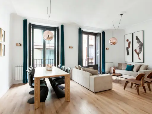 Amplio salón comedor rectangular de 25 metros con sofás, mesa de madera y sillas modernas.