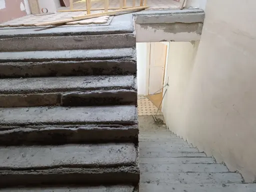 Surowe schody betonowe czekają na malowanie lastryko. Trwa remont klatki schodowej.