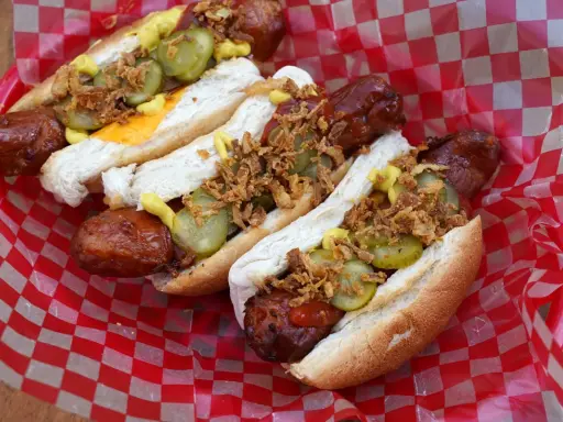 Heißer Hot Dog aus dem Airfryer, belegt mit Gurken, Zwiebeln und Senf. Perfekt für einen schnellen Snack!