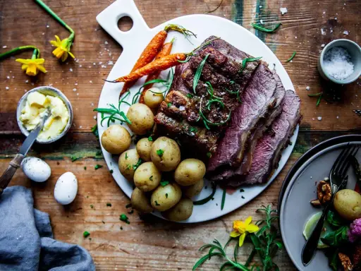 Helstekt biff med kappa, serverad med småpotatis och morötter. En festlig måltid som passar perfekt för påsk.