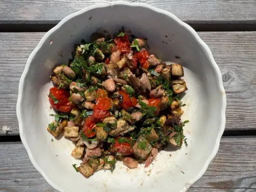 Bunter Gemüsesalat mit Auberginen, Tomaten und Bohnen, garniert mit Petersilie. Ein gesundes Gericht, inspiriert von TCM-Rezepten.