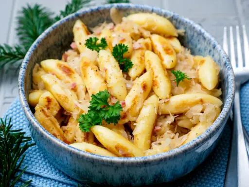 Herzhafte Schupfnudeln mit Sauerkraut, garniert mit Petersilie. Ein Klassiker, der auf keinem Tisch fehlen darf.