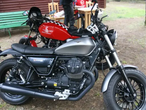 Dwa motocykle Moto Guzzi, jeden srebrny, drugi czerwony z szachownicą. Może to przypomnienie o opłacie skarbowej za motocykl z zagranicy.