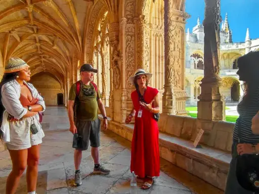 Besucher lauschen einer Führerin im Jeronimos Kloster. Die Architektur ist detailreich und beeindruckend.