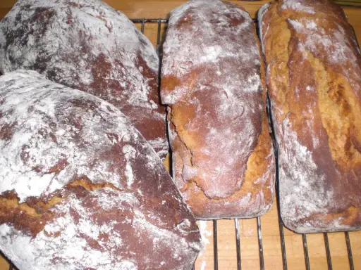 Nybakade sirapslimpor, pudrade med mjöl, redo att avnjutas. Ett perfekt sirapslimpa recept för hembakat bröd.