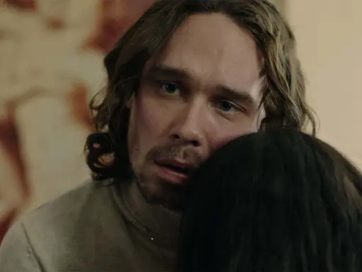 En man med långt hår och blå ögon kramar någon i tv-serien "Knutby".