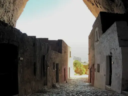 Antica via acciottolata che conduce verso il mare, incastonata nella roccia della grotta Mangiapan.