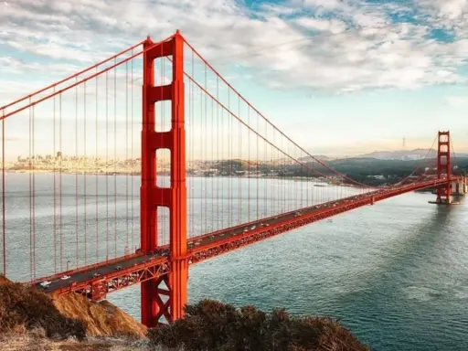 El icónico puente Golden Gate, con su distintivo color naranja, se extiende sobre el agua. ¿Cuánto mide el puente de San Francisco? Es una maravilla de la ingeniería.