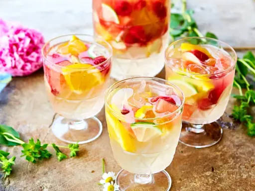 Färgglad vit sangria med frukt som apelsin, lime och hallon. Perfekt för en sommardag, här är ett enkelt recept.
