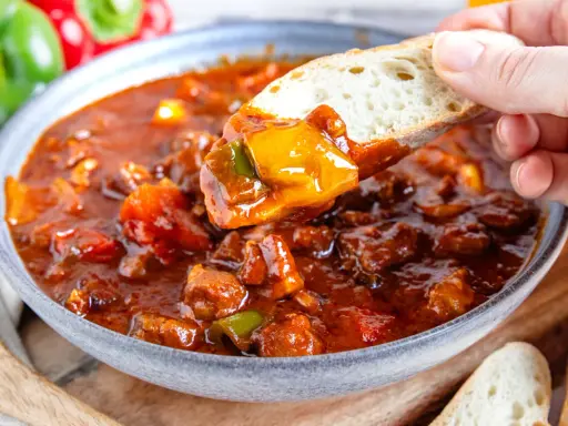 Herzhaftes Schaschliktopf Rezept mit Fleisch und Paprika, serviert mit frischem Brot.
