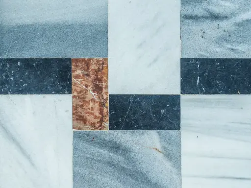 Wzór płytek marmurowych z widocznymi drobnymi rysami, sugerujący usuwanie rys z płytek szkliwionych.