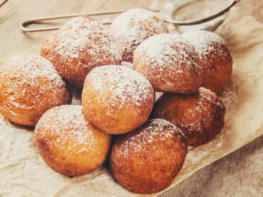 Délicieux beignets saupoudrés de sucre glace, rappelant la recette pâte à beignets de grand-mère. Un délice croustillant et moelleux.