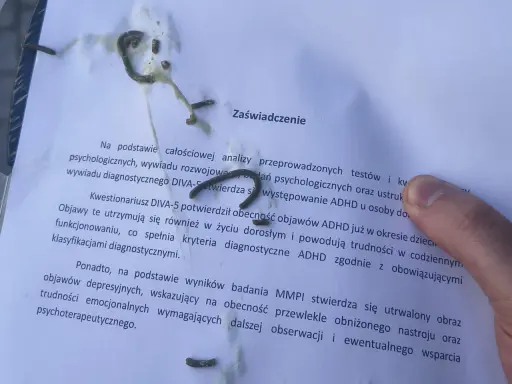 Na zaświadczeniu o ADHD, obok tekstu, widać ślady czegoś, co może przypominać trudności w pisaniu, jak przy dysgrafii.