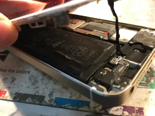 Naprawa iPhone po zalaniu. Widoczna otwarta obudowa, bateria Li-ion i elementy wewnętrzne.
