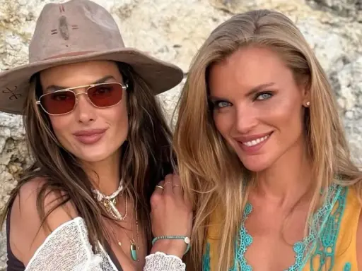 Alessandra Ambrosio y una amiga sonríen a la cámara, luciendo gafas de sol y joyas veraniegas.