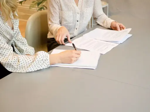 Nauczycielka z uśmiechem pisze na tablicy, przygotowując materiały na kolejne dni robocze.