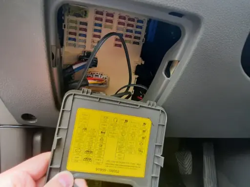 Wnętrze samochodu z otwartą skrzynką bezpieczników. Na klapce schemat, w tym oznaczenie dla navitel smart box max.