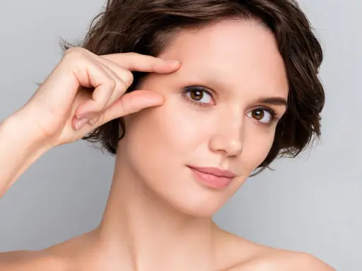 Une femme examine son visage, préoccupée par une possible alopécie sourcil.