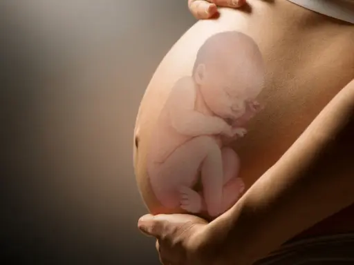 Pancia di donna incinta con immagine sovrapposta di un feto in posizione podalica, con le gambe rivolte verso il basso.