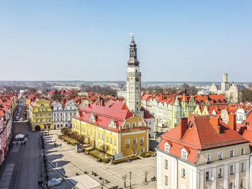 Rynek w Bolesławcu z ratuszem i wieżą zegarową. Kolorowe kamienice i brukowany plac tworzą urokliwe bolesławiec atrakcje.