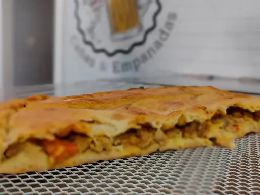 Empanada dorada rellena de carne y verduras. Perfecta para acompañar con una ensalada fresca o una salsa picante.