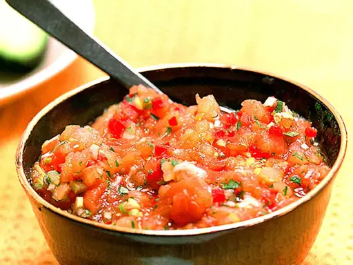 En skål med färsk pico de gallo, en klassisk mexikansk salsa med hackade tomater, lök och koriander. Perfekt till tacos!