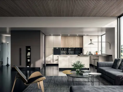 Un elegante appartamento open space moderno con cucina a vista, zona living con divano grigio e poltrona di design.