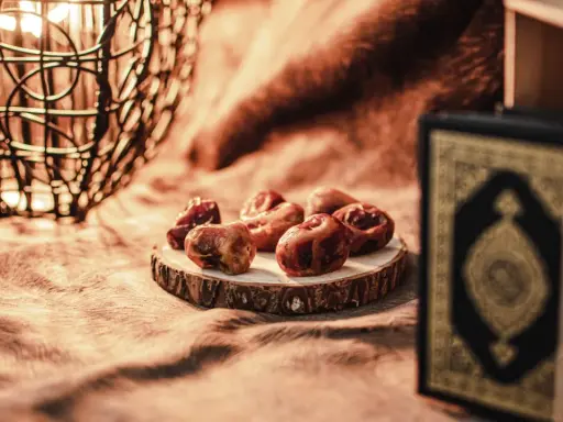 Datteln und ein Koran symbolisieren das Ende des Ramadan. So feiert man warum feiert man zuckerfest.
