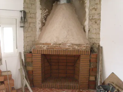 Construcción de chimenea de obra. El hogar de ladrillo y la campana cónica de cemento están en proceso. Aprende como hacer una chimenea de obra que no haga humo.