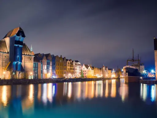 Nocny Gdańsk, Żuraw i zabytkowe kamienice odbijające się w wodzie. Wspaniałe atrakcje pomorskie.
