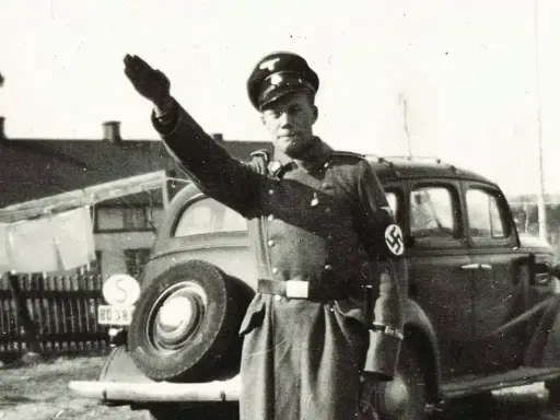 En man i uniform med hakkors hälsar. Bilden visar svenska nazister.