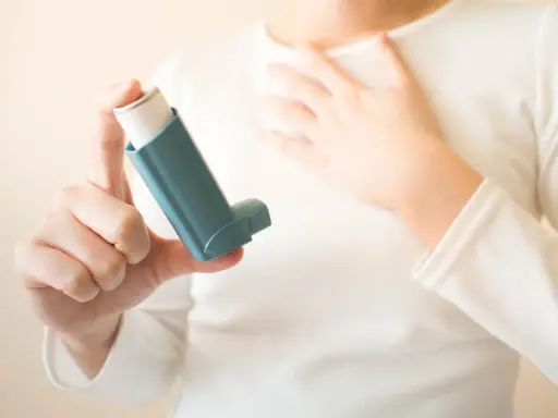 Person hält einen Inhalator, ein wichtiges saba Medikament, um Atemnot zu lindern.