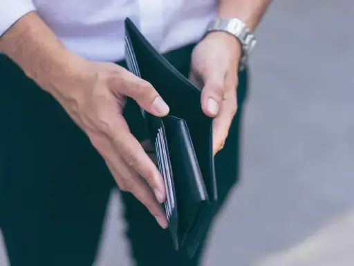 Puste ręce trzymające portfel, symbolizujące trudności finansowe i przykłady stagflacji.
