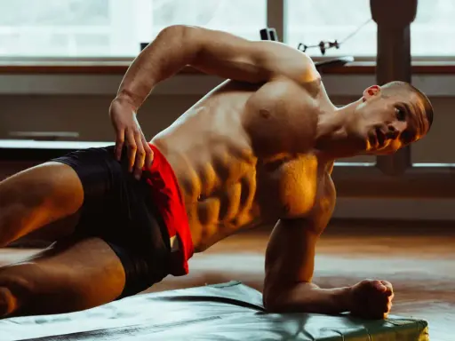 Mann macht seitliche Planke für Bauchtraining mit Hanteln.