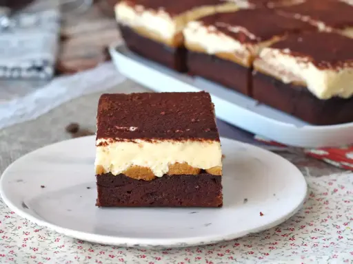 Pyszny deser tiramisu przepis. Warstwy czekoladowego ciasta, biszkoptów i kremu, posypane kakao.