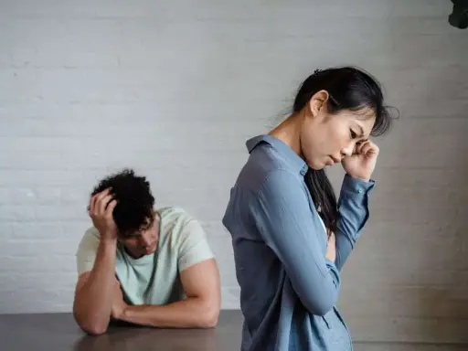 Pareja con expresiones de desánimo, uno con la mano en la cabeza, el otro pensativo. Un reflejo del refuerzo intermitente en la pareja.