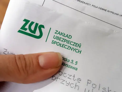 Palec wskazujący na dokumencie ZUS. Pytanie: ile trzeba być na zwolnieniu aby dostać odszkodowanie z ZUS?