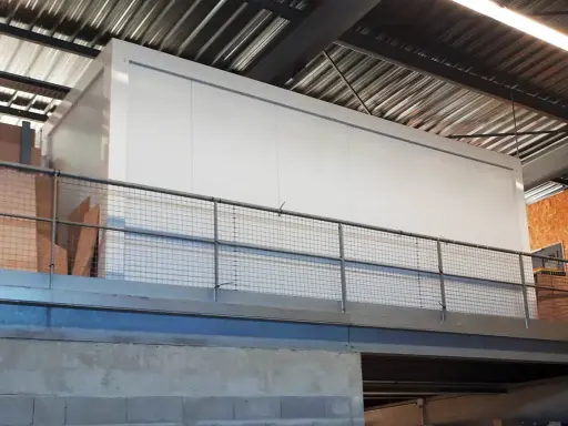 Un grand module blanc, peut-être une chambre froide, est installé dans un entrepôt. Le **REI 120 signification** est la résistance au feu de 120 minutes, une norme de sécurité essentielle.