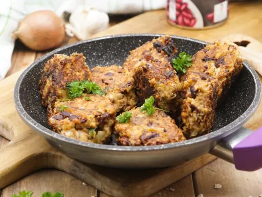 Herzhafte vegetarische Frikadellen mit Kidneybohnen, frisch in der Pfanne gebraten und mit Petersilie garniert.