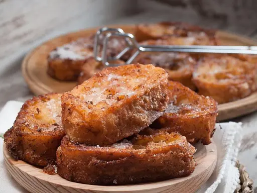 Torrijas caseras, doradas y espolvoreadas con azúcar. Una deliciosa receta para disfrutar.