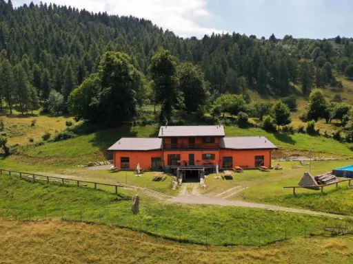 Un weekend in Lombardia tra natura e relax: casa arancione con piscina immersa nel verde, ideale per scoprire cosa fare nel weekend in Lombardia.