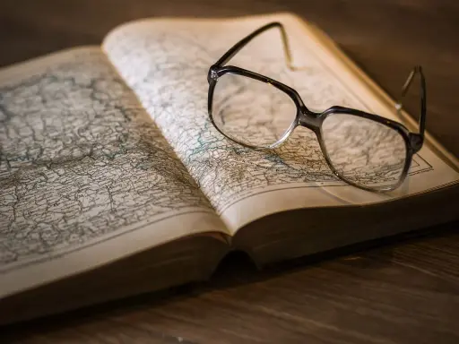 Okulary na starej mapie, symbolizujące wiedzę i naukę, jak w pruskim systemie edukacji.