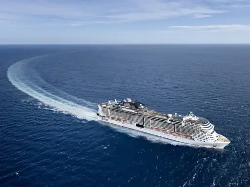 La MSC Virtuosa, con la sua impressionante lunghezza, solca le acque blu lasciando una scia bianca.
