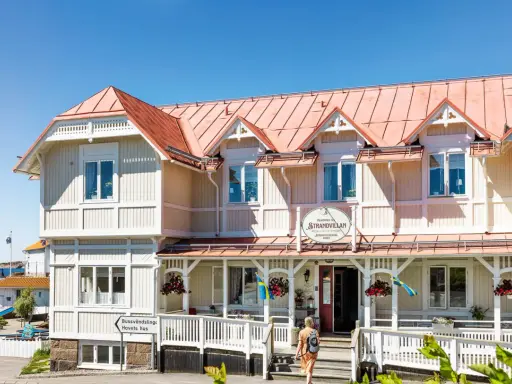 Välkommen till Strandvillan i Lysekil, ett charmigt hus vid havet med röda tak och vita detaljer.