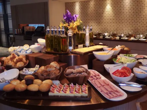 Ideas para buffet desayuno hotel: croissants, pasteles de fresa, jamón, ensaladas, frutas y panes.