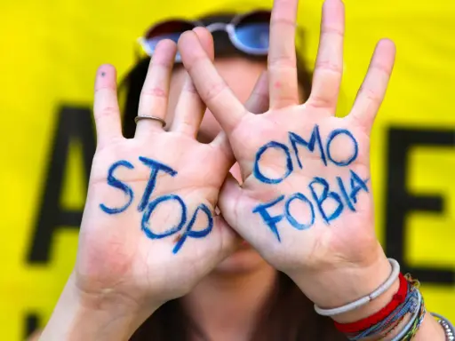 Mani con scritto "STOP OMOSESSUALITÀ" in blu, un messaggio contro il bullismo omofobico.