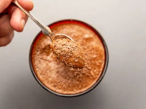 Ein Löffel mit Schokostückchen auf einer cremigen Mousse au Chocolat. Das Originalrezept für puren Genuss.
