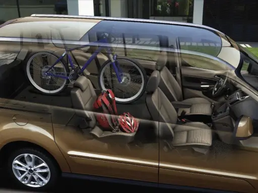 Interior de furgoneta con bicicleta azul y cascos rojos. ¡Cuidado con la multa por llevar bici dentro del coche!