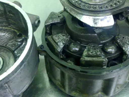 Zużyty sprzęgło klimatyzacji z widocznymi elementami mechanicznymi i łożyskami.